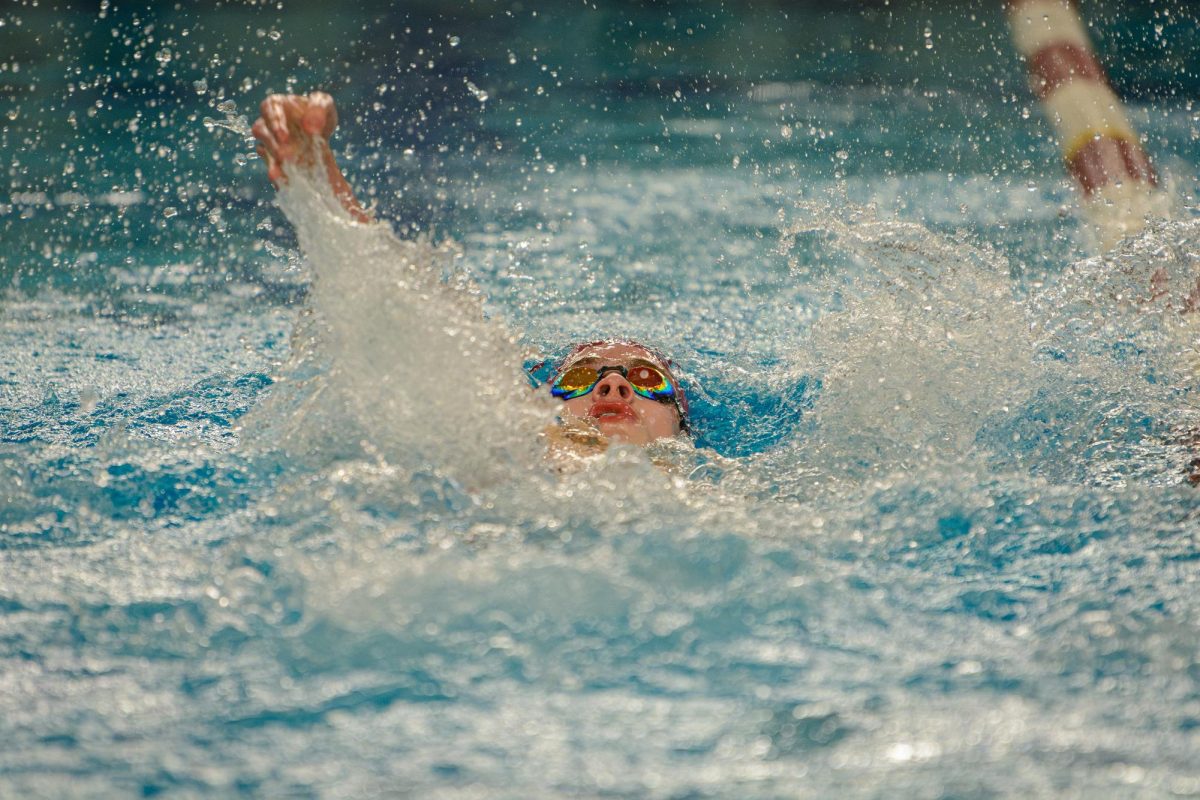 Sophomore Ethan Barrett keeps his head above the water while he races the backstroke.
