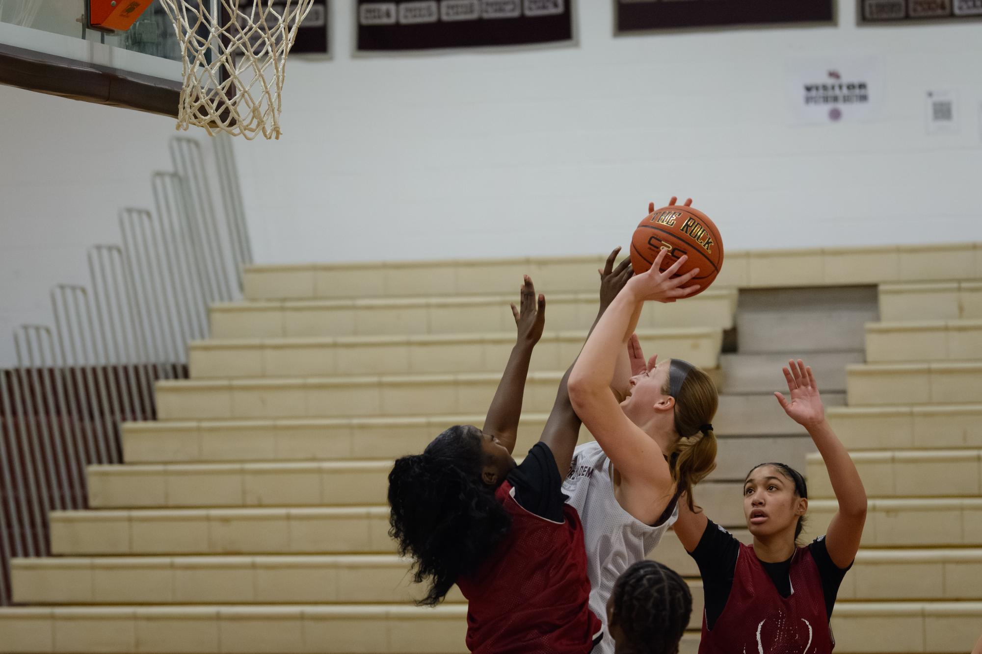 Senior captain Kaitlyn Pepin attempts to score a basket while being guarded by Lowell players.