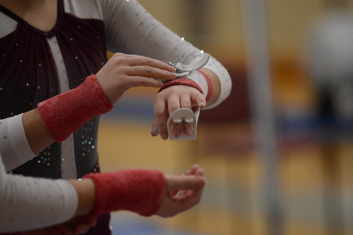 Gymnasts wrap grips around their hands.