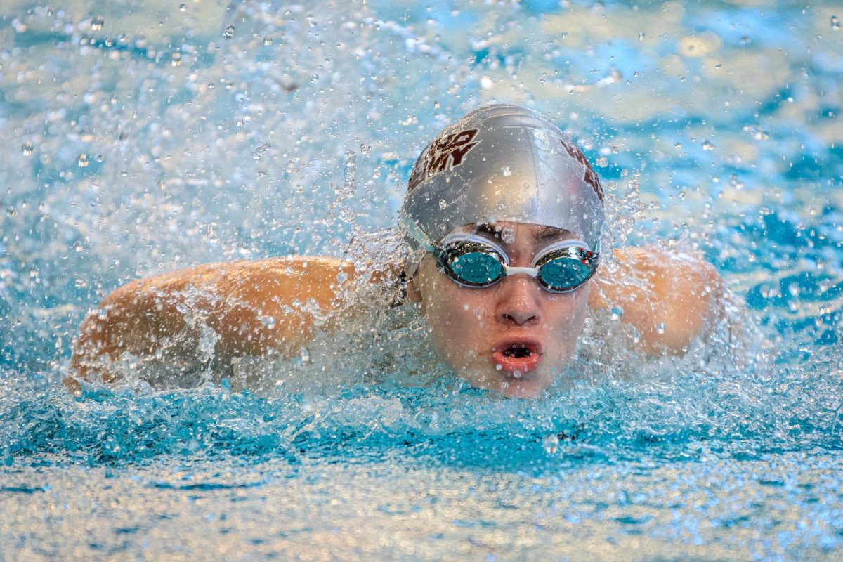 Freshman Mila Munichiello sticks her head out of the water for a breath of air during the butterfly. 