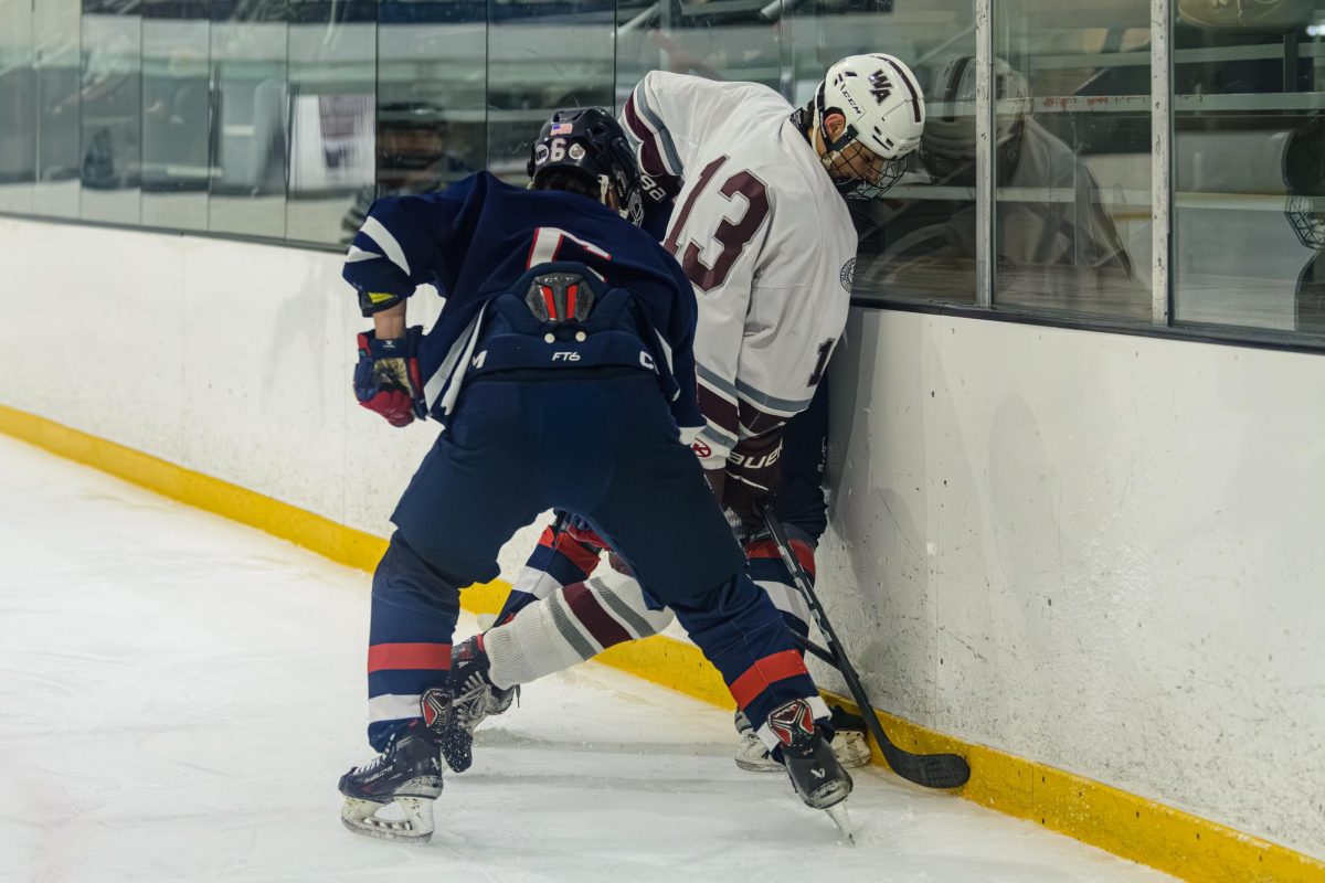 Junior James Roberts fights for the puck against Lincoln-Sudbury players.