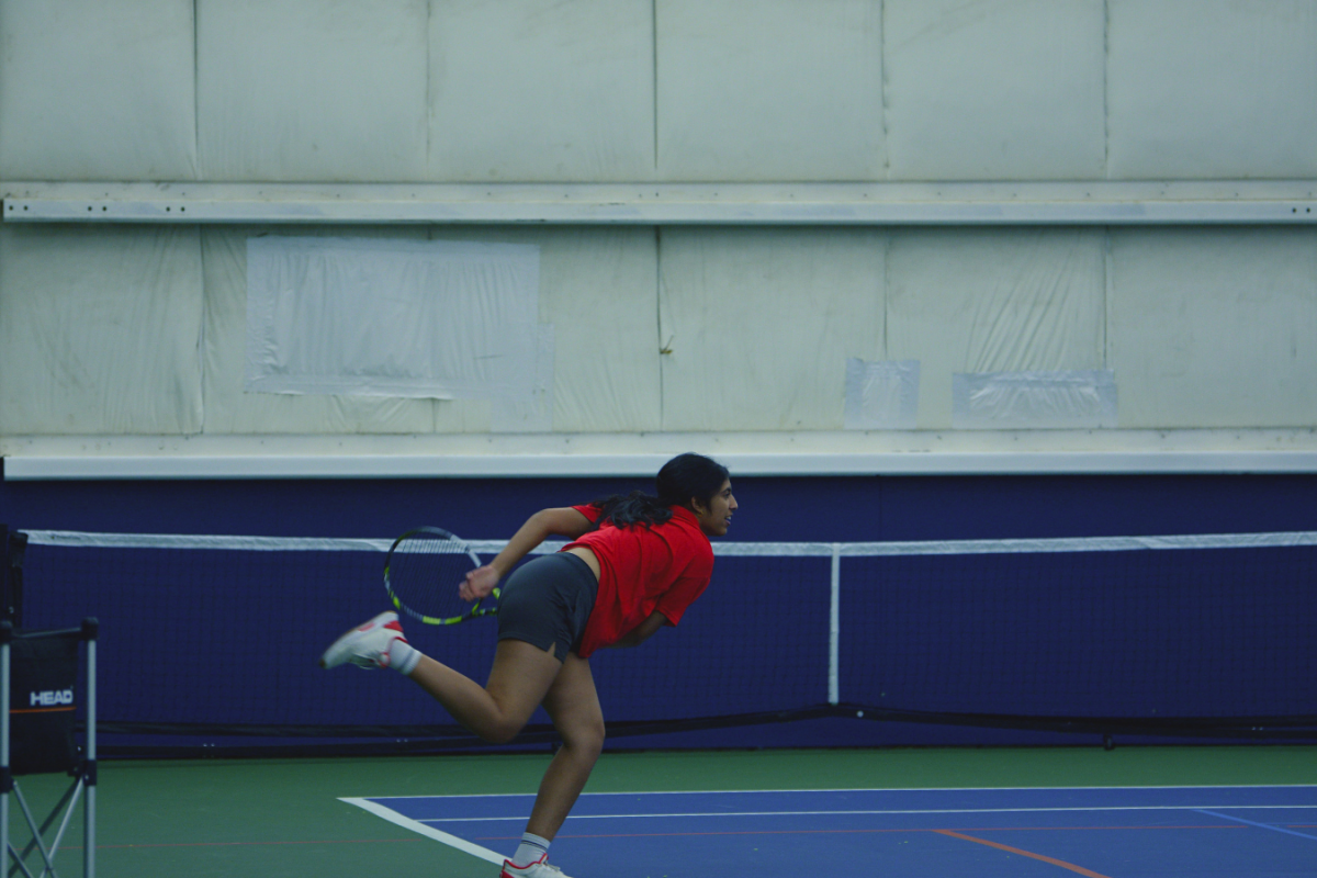 Junior and varsity tennis player Sohana Arani follows through with a sharp serve during tryouts. March 16 through March 19, girls will be assessed on their skills and dedication. 