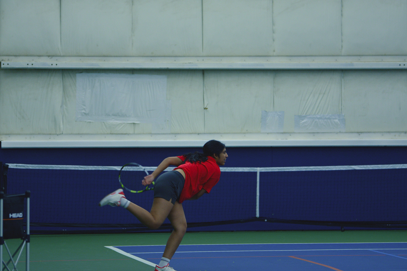 Junior and varsity tennis player Sohana Arani follows through with a sharp serve during tryouts. March 16 through March 19, girls will be assessed on their skills and dedication. 