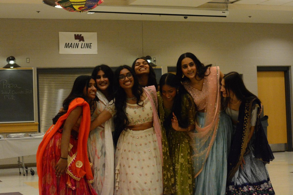 The final senior group laughs with their arms around one another, ending the performances. 