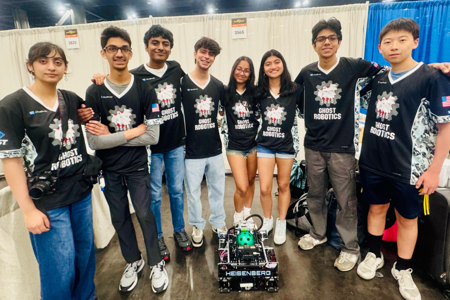 Robotics team poses for a photo with their robot.
