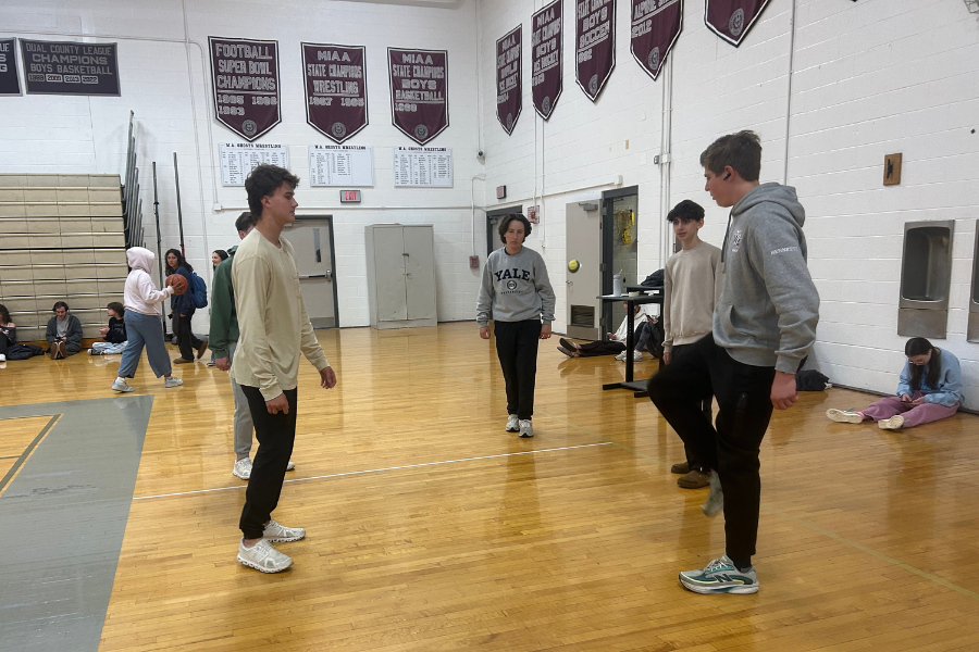 A group of students playing hacky sack in the main gymnasium.