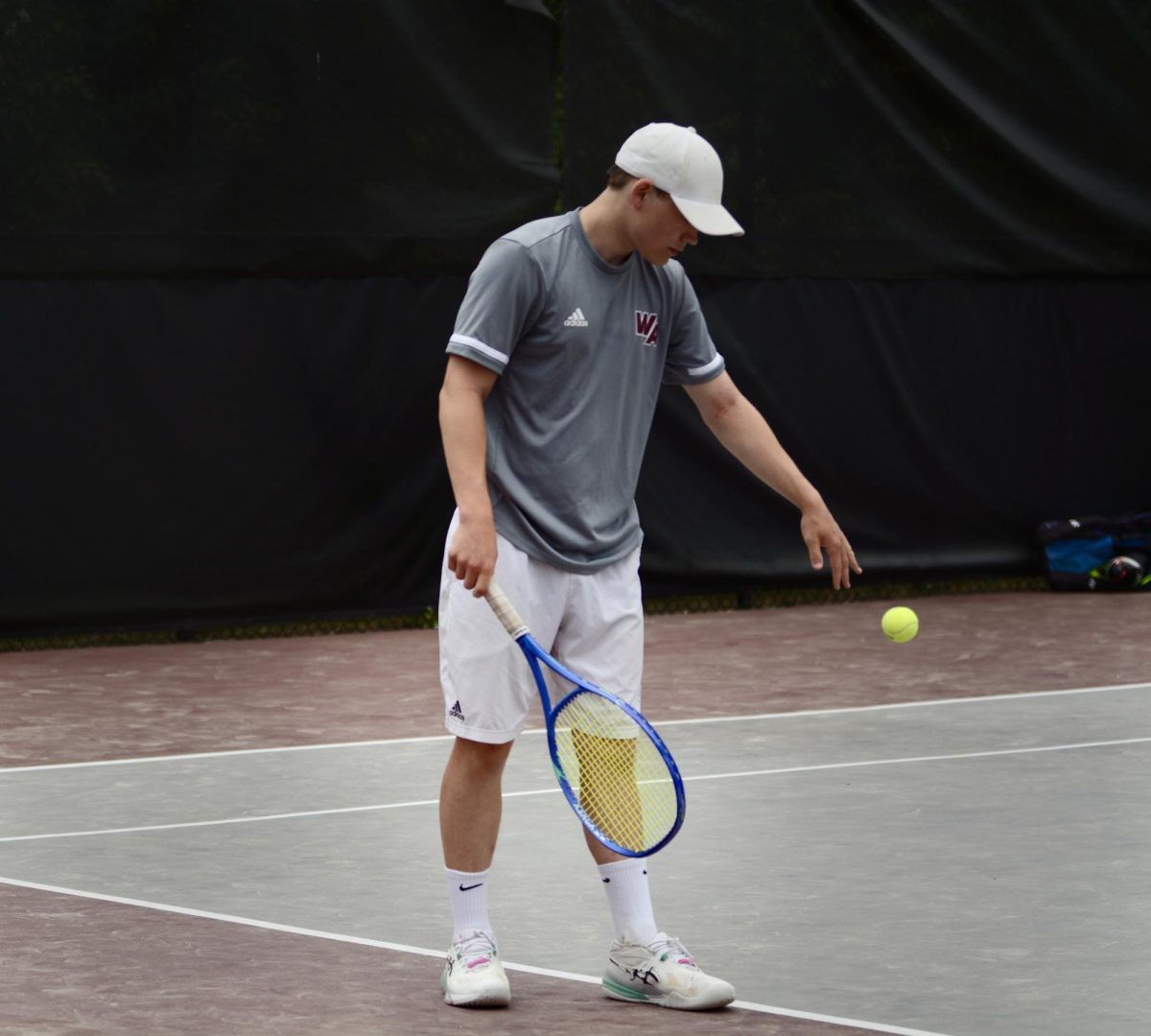 Junior Josh Madsen steps on the service line, establishing his rhythm before delivering a serve.