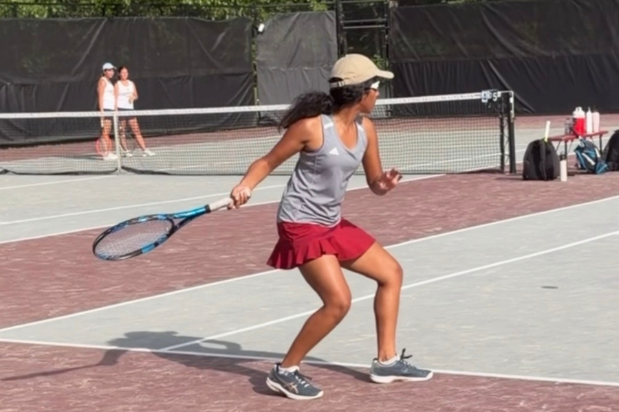 Goyal swings her racket, volleying the ball across the net.